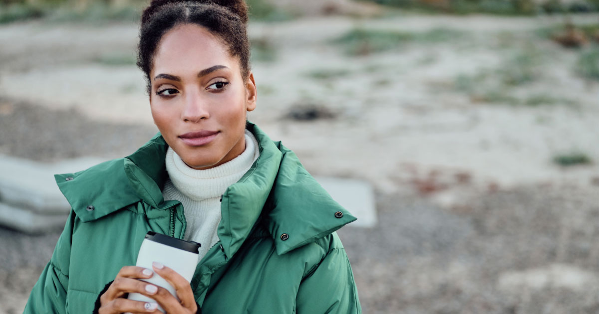 Woman keeping warm with lightweight green jacket on