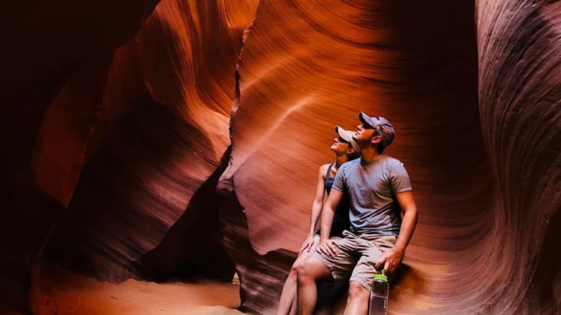 couple sitting and posing for a photograph in lower antelope canyon